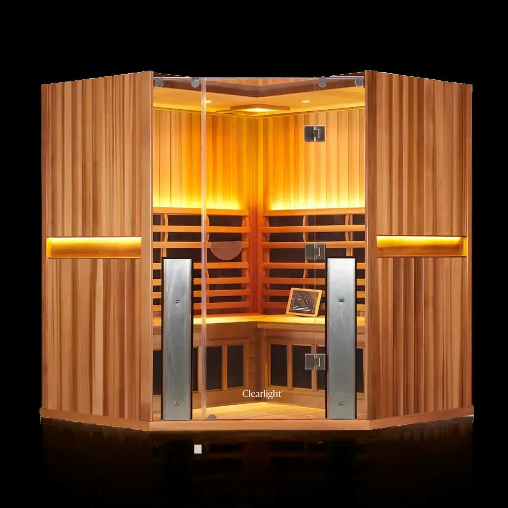 Clearlight Sanctuary C corner sauna in reddish wood, angled glass front and warm-lit interior benches